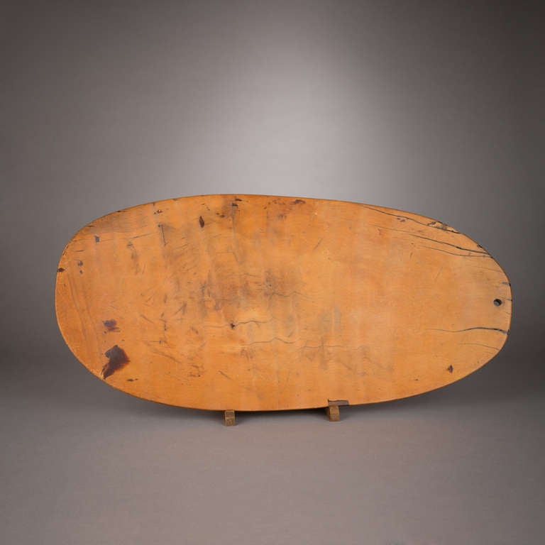 A well-aged meat platter (pa laau) from the Hawaiian Islands. The shallow, warmly colored dish was carved from a single, slender plank of wood, likely from the Artocarpus altilis, or breadfruit tree. It is pierced at one end by a small hole which