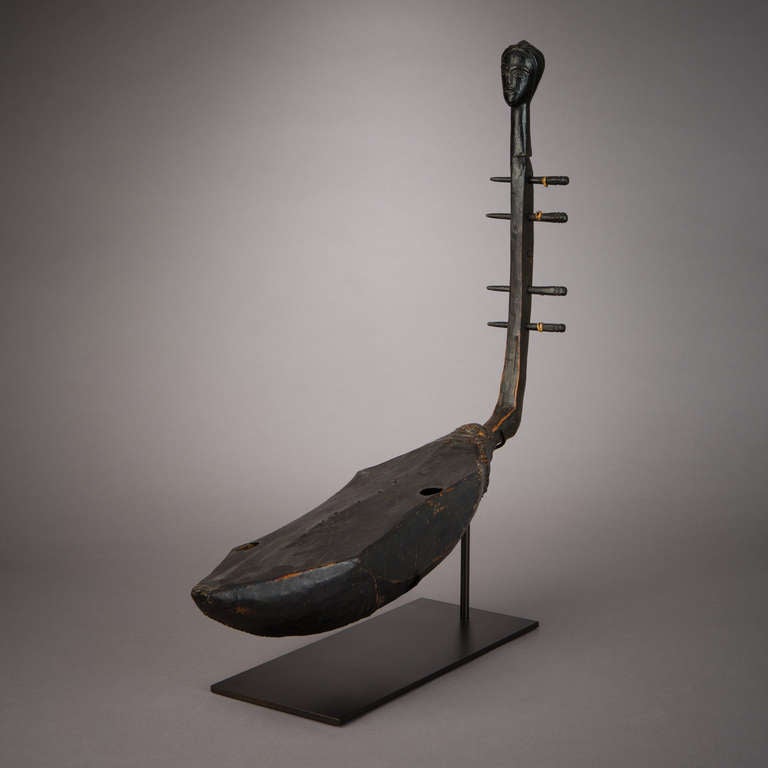 Eine seltene figurative Harfe aus dem Volk der Vuvi oder Tsogo in Gabun. Es ist ein Instrument, das traditionell von jungen Männern und Jungen gespielt wird. Diese seltenen Instrumente sind vor allem für ihre kunstvoll geschnitzten Köpfe