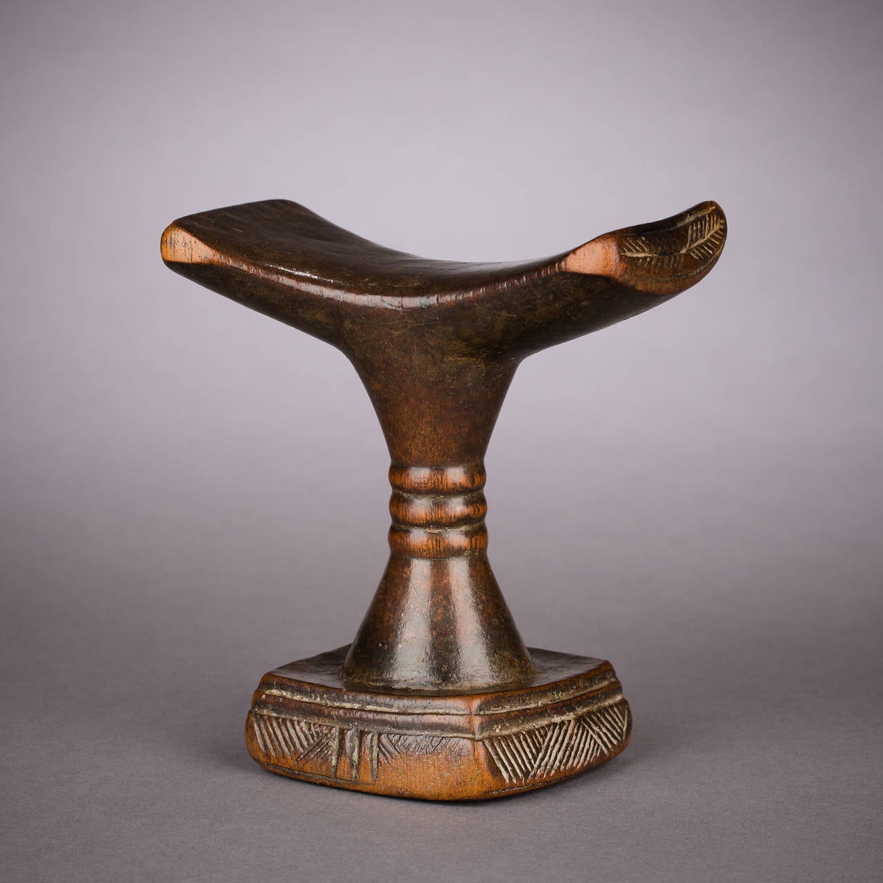 A stately, exalted quality of form marks this gorgeous Luba headrest. At just over six inches in height, the piece achieves an almost monumental stature with its strong, upreaching silhouette and finely proportioned, anchoring base. The lovely,