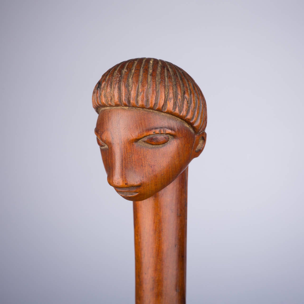 This beautiful staff finial embodies the essence of South African woodwork, presenting a composition of perfectly simple, sensitive, understated shapes. The soft features of the face place wide-set eyes and a flat, wide nose over a small, subtle