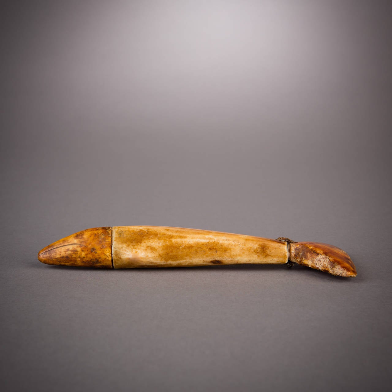 This whale amulet would have been carried in its owner's hunting bag. A simple yet complete image, this figurine expresses such an economy of detail and yet leaves nothing out. The warm, mottled patina the ivory has grown over centuries lends the