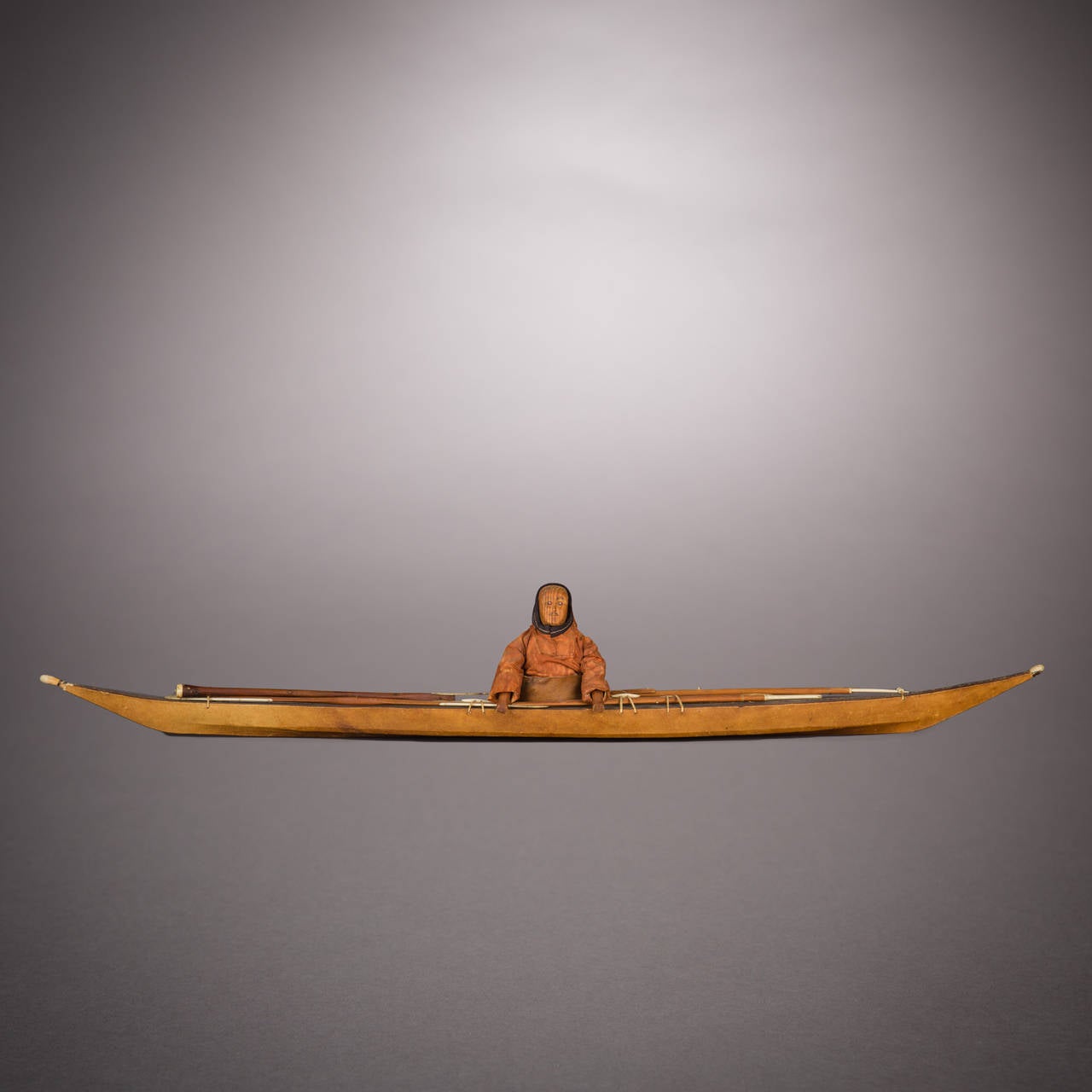 This is a splendid and uncommonly large model of a Greenland kayak, amply illustrating a substantial complement of hunting gear and a pilot's set of waterproof garments. Carefully worked ivory was used to detail various equipment elements and