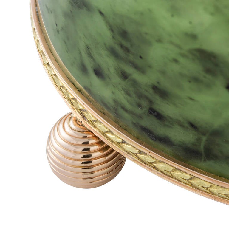 A late nineteenth century Fabergé nephrite cache pot carved from a single piece of nephrite, the two colour gold rim top and base decorated with acanthus leaves, three gold ball feet, dimensions approximately 9.5cms x 6.7cms, workmaster Michael