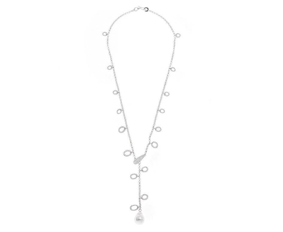 A wonderful and ornate diamond and cultured baroque pearl necklace (49cm in length). A white gold fine belcher chain is decorated with diamond encrusted oval motifs with a pave set diamond panels with a beautiful cool white shimmering pearl drop. A