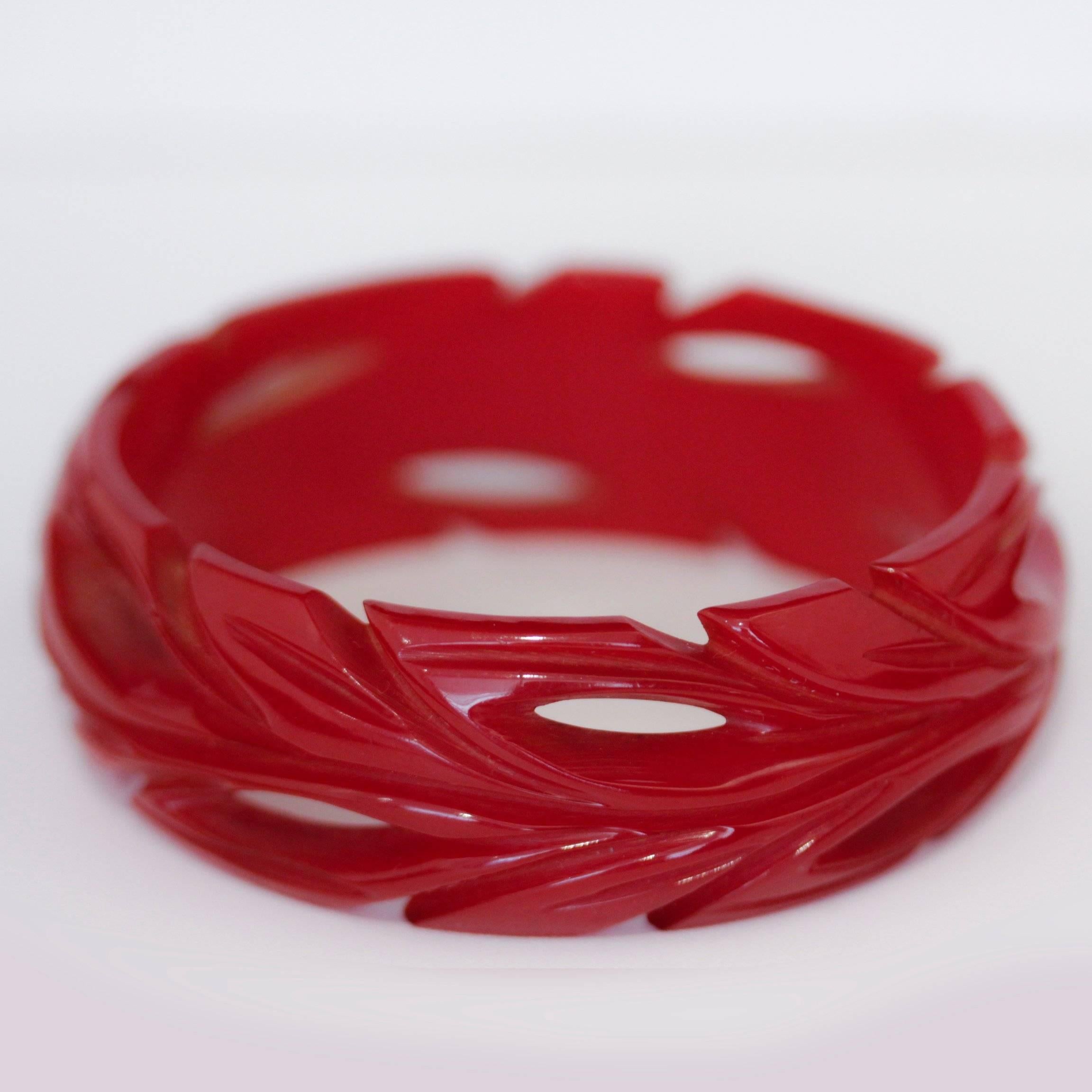 Art Deco cherry red bakelite bangle with deep leaf carvings and cut outs. Beautiful, easy to wear, and like all Vintage Times Bakelite, guaranteed to be genuine.

Dimensions - Width 2 cm
Internal diameter - 6 cm