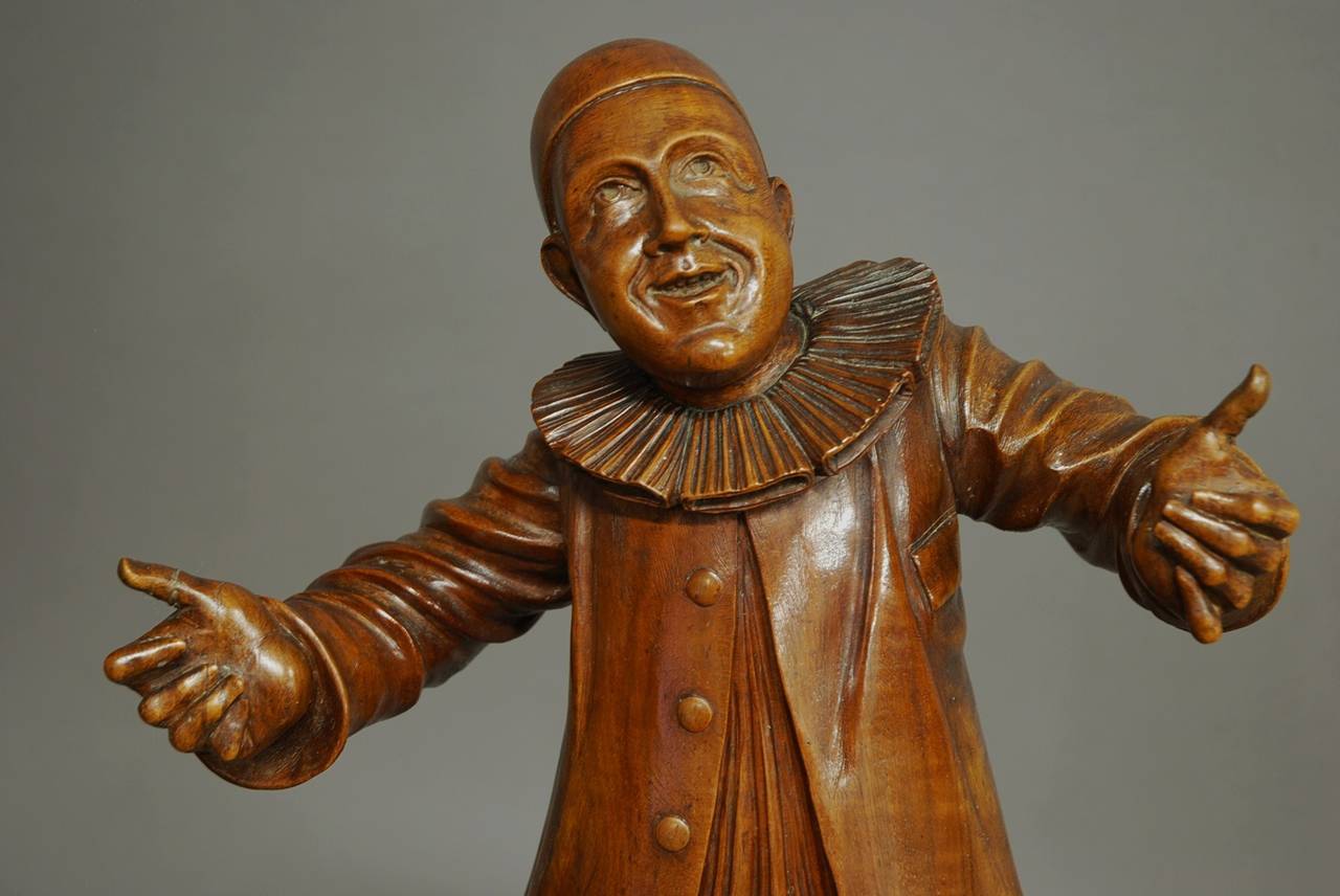 A late 19th century French finely carved walnut figure of a Pierrot.

The Pierrot stands on a plinth wearing his characteristic clothing of the skull CAP, frilled collaret, loose shirt with large buttons and pantaloons. 

He is finely carved and