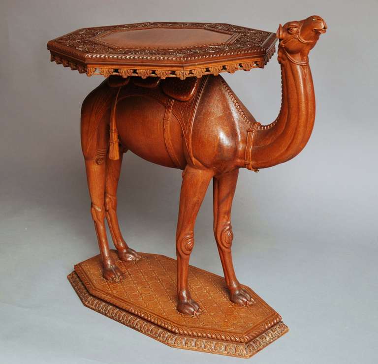 A late 19th-early 20th century Anglo-Indian hardwood camel table of superb quality, possibly from the Gujarat region. 

This table has an octagonal top with a plain central section, surrounding this a profusely carved foliage design with a