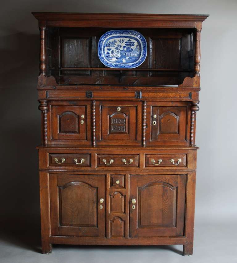 A mid 18th century Welsh oak cwpwrdd tridarn (three part cupboard) of superb patina (colour), probably from the Snowdonia region.

The tridarn consists of an open section to the top with turned columns at either end, the sides having desirable wavy