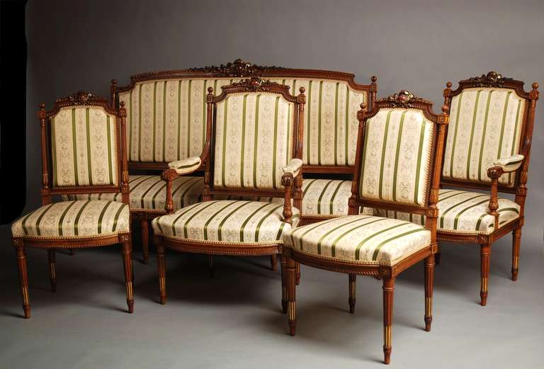 A late 19th century superb quality French 5 piece carved walnut & parcel-gilt salon/parlour suite in the Louis XVI style.

This suite comprises of a sofa, 2 armchairs and 2 single chairs.

The sofa and chairs all have an arched top rail with a 