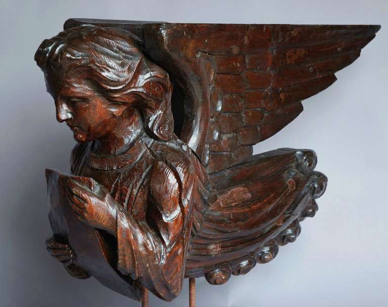 A highly decorative 17th century and later pine finely carved Continental Roof Angel, probably French. 

The angel has large wings, possibly added in 18th century, and is holding a book or possibly a bible.

This figure would have come form a