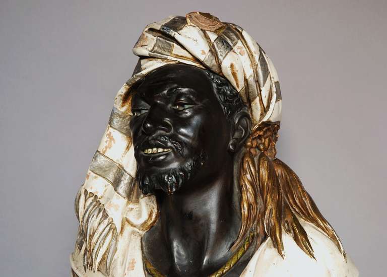 A highly decorative late 19th century /early 20th century life size Austrian painted terracotta bust of a Nubian man by Koenig & Lensfeld.

This figure is finished in exotic traditional dress with a shawl and necklace and a fez hat.

He sits on