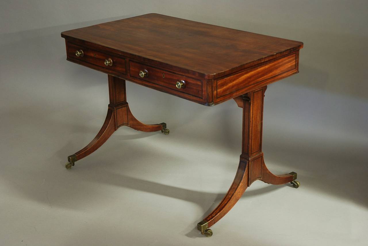 An early 19th century mahogany writing table of good proportions.

This table consists of a fine quality veneered mahogany top.

Below this are two oak lined drawers with two dummy drawers to the opposite side, all with inlaid ebony stringing