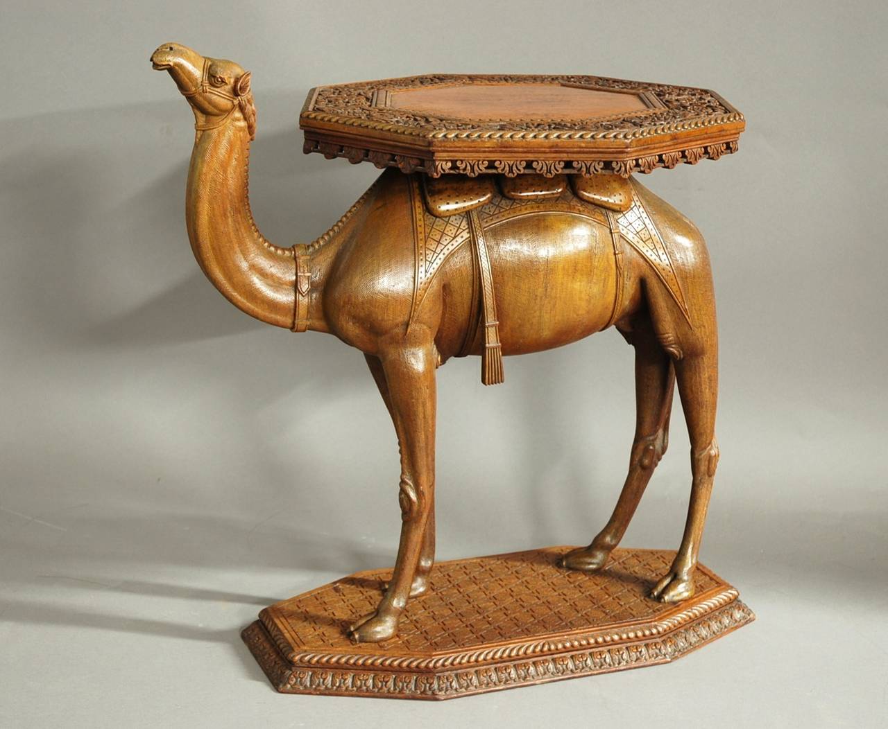 A late 19th-early 20th century, Anglo-Indian hardwood camel table of superb quality and good patina, possibly from the Gujarat region of India. 

This table consists of an octagonal top, the central section surrounded by a profusely carved foliate