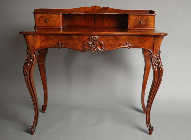 A mid-19th century French mahogany bonheur da jour (lady's writing desk) of exceptional quality. This piece is superb quality and has a great choice of mahogany curl veneers. There is a shaped gallery at the top with a shaped shelf, supported by two