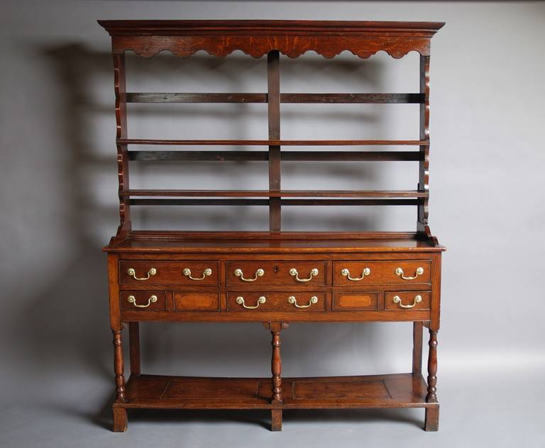 An early/mid 19thc Welsh oak pot board dresser and rack of small proportions of good patina (colour) possibly from the Cardiganshire region in Wales.

The open rack consists of a shaped moulding with shaped frieze, leading down to two shelves with