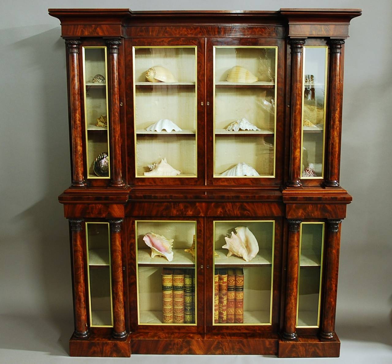 A superb quality William IV mahogany inverted breakfront bookcase of small proportions.

This bookcase consists of a top and bottom section, the top section has a moulded cornice with a superb curl mahogany veneered frieze supported by four glazed