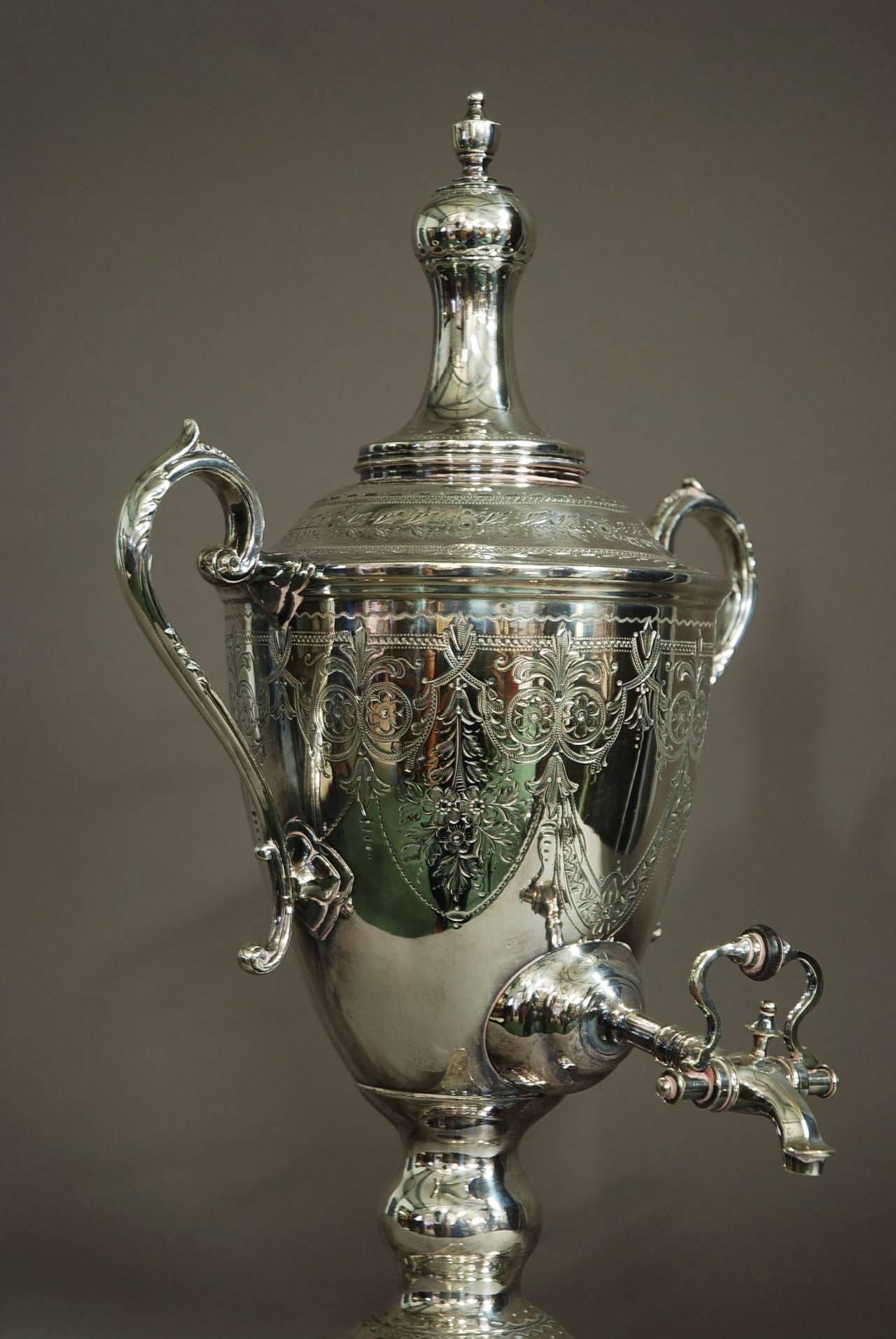 A good quality late 19th century silver plate vase shaped tea urn.

The main body of the urn is of Classical vase shaped design.

The piece has scrolling foliage handles and is decorated with elaborate Classical engraving of floral and foliage