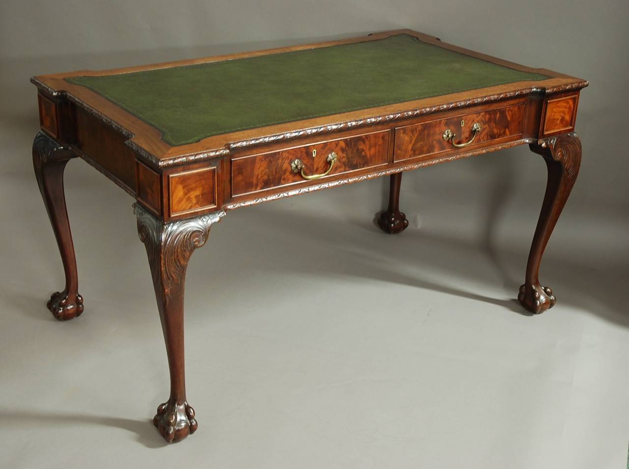 A late 19th century/early 20th century Waring & Gillows mahogany writing table in the Chippendale style.

This table consists of a rectangualr top with re-entrant corners with an inset green tooled leather top, recently replaced, with a carved