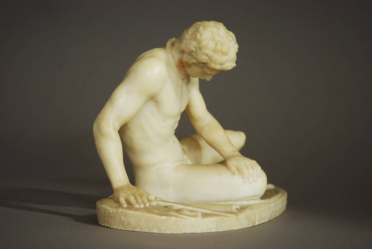 A Grand Tour early 19th century Italian alabaster figure of 'The Dying Gaul' on integral oval base, after the antique.

The Dying Gaul or Dying Gladiator is depicted in his final moments next to his shield and sword, his face in pain with a fatal