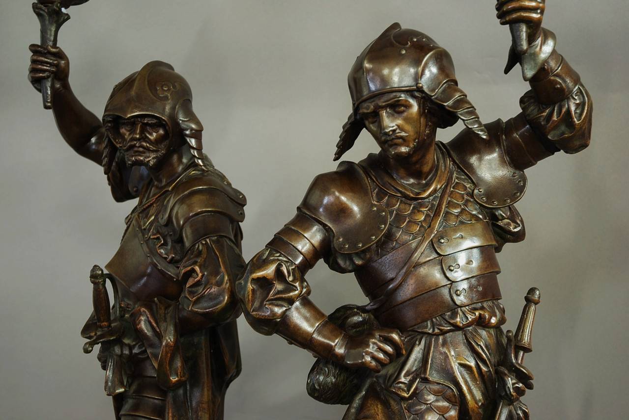 A large pair of French superb quality 19th century bronzed spelter figures in the form of 16th century warriors in full armour and draped cloaks, each with flambeaux aloft.

Each warrior is holding a flambeau, not electrified at present (but could