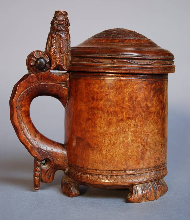 A late 18th century Norwegian burr birch peg tankard with rich patination. 

The lid has foliate design with a four-leaf clover carving with intricate detailed design surrounding it. 

The thumb knob is also intricately carved with fluting with