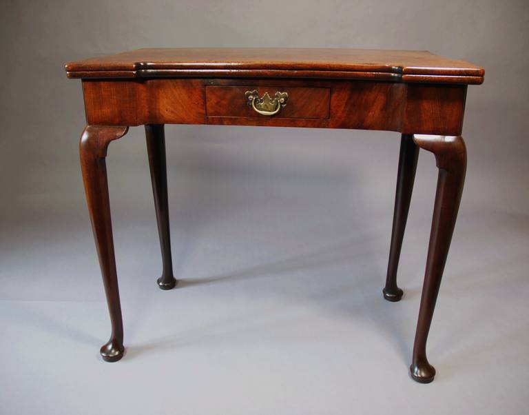 An 18th century mahogany card table of exceptional patina (color).

The table consists of a mahogany top of a re-entrant shape, the top opens to reveal a green baize surface.

This leads down a frieze, also of re-entrant form, with a small oak