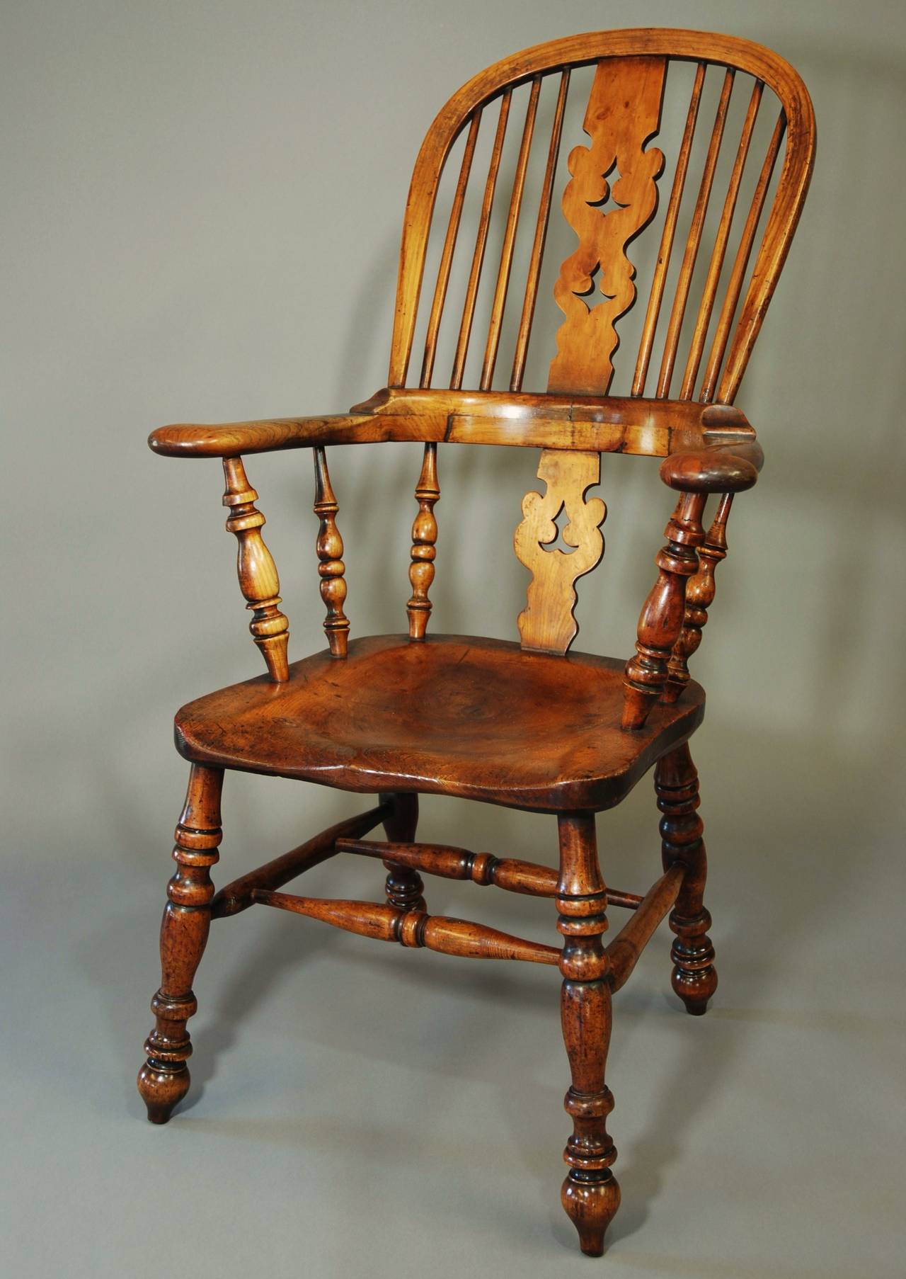 A mid-19th century broad armed fruitwood high back Windsor chair from the North country, probably Yorkshire.

This chair has a lovely patina and is made of various woods, the seat being elm, the back splat yew & the majority of this piece is made