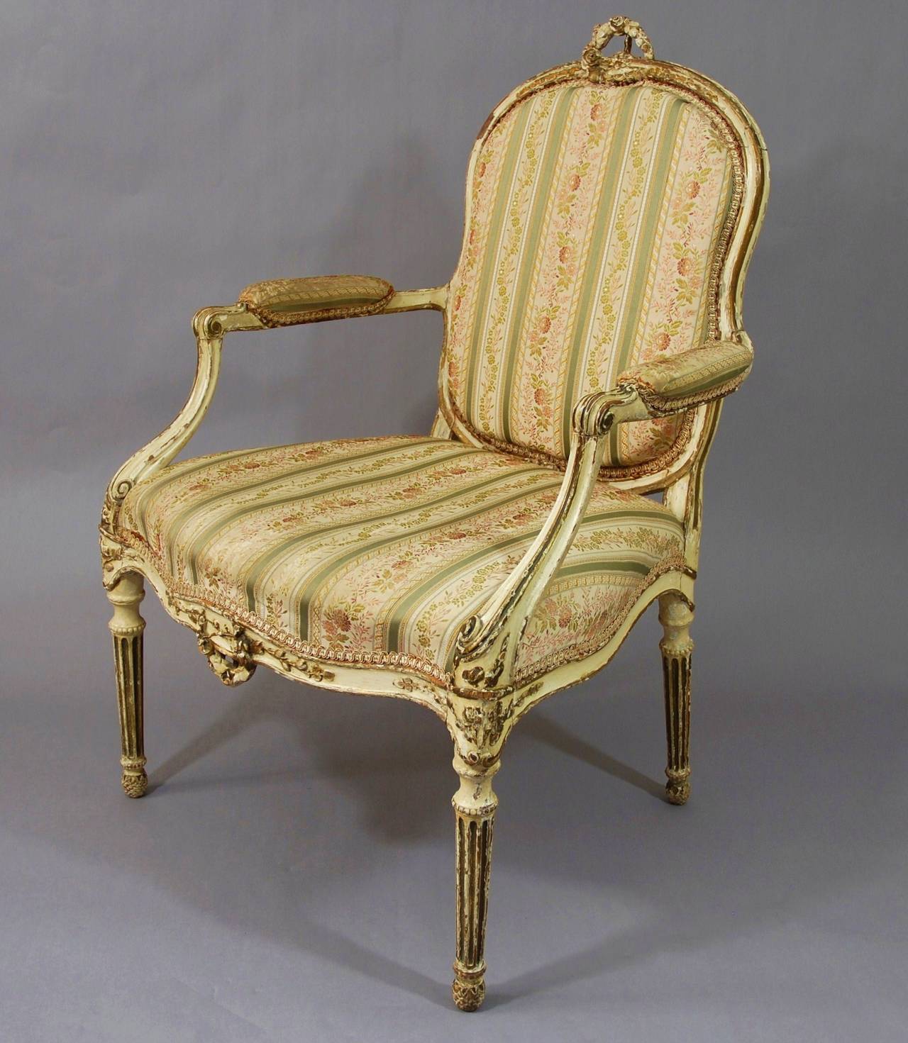 A very decorative 18th century, French painted open armchair.
 
The legs are turned & fluted & terminate with a pineapple foot. 

The serpentine front rail and the top rail are decorated with a foliage wreath.

The chair was from a private