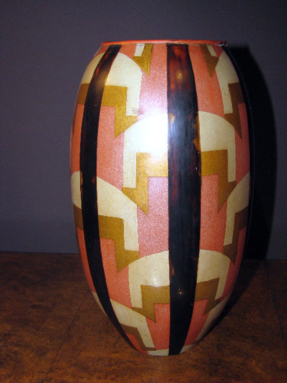 Metal egg-shaped vase on a pink lacquered ground with geometric patterns of stylized bridges and tortoise shell lacquer strips.
A few lacquer chips around the neck.