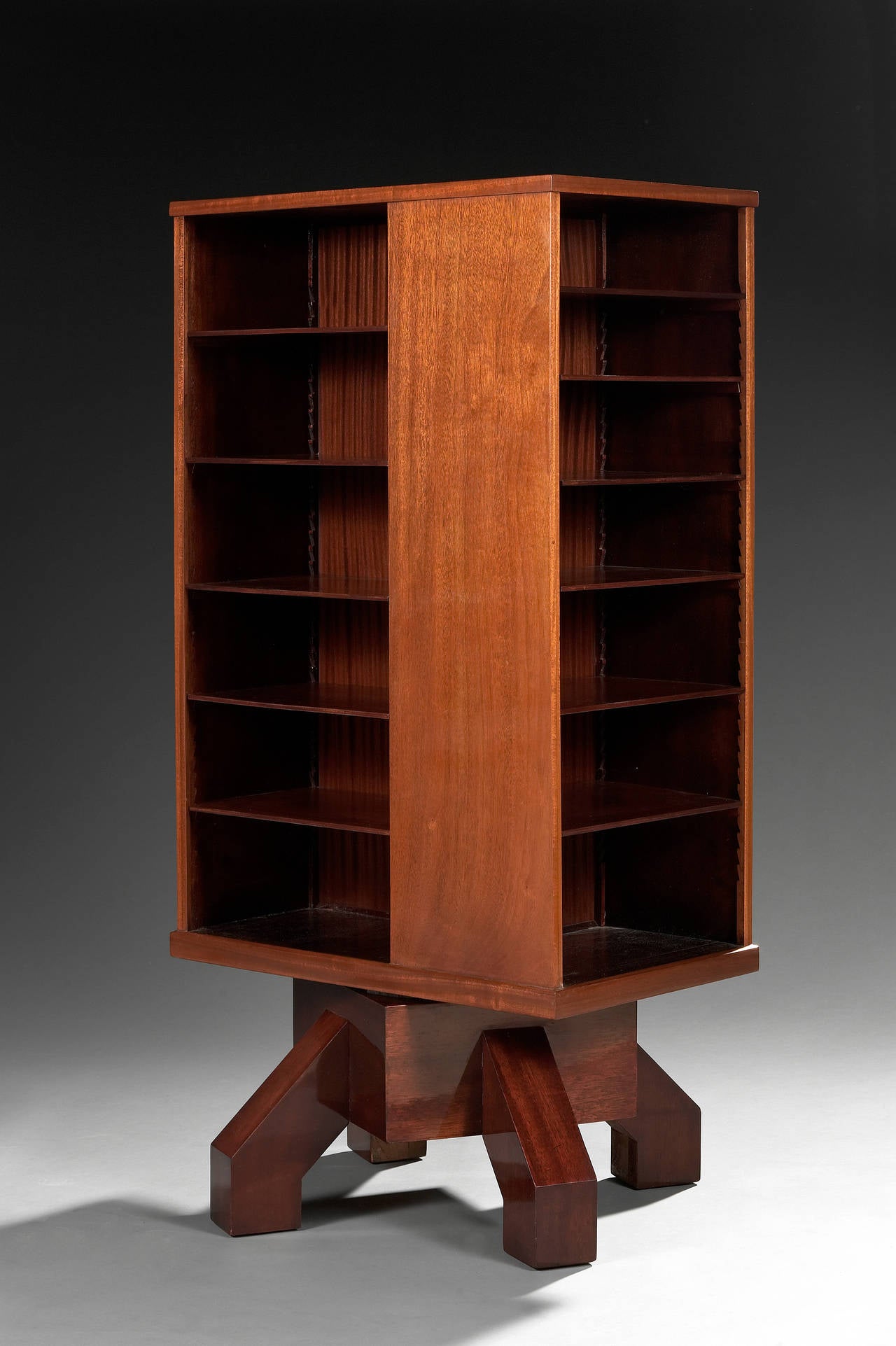 Mahogany seance bookcase with multiface quadrangular body and open shelves. One of them with a drawer. Four legs on square base.