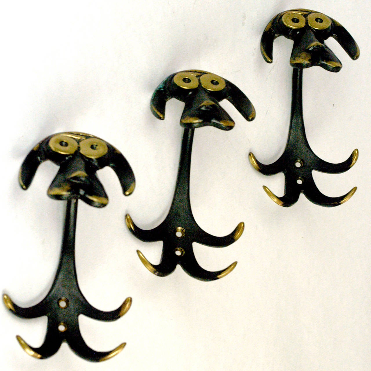 Amazing dog shaped, partly black finished brass hooks by the Austrian artist Walter Bosse
Also available as single.
This set is a characteristic work of the Austrian midcentury artist and designer Walter Bosse, who is famous for his hümoristic