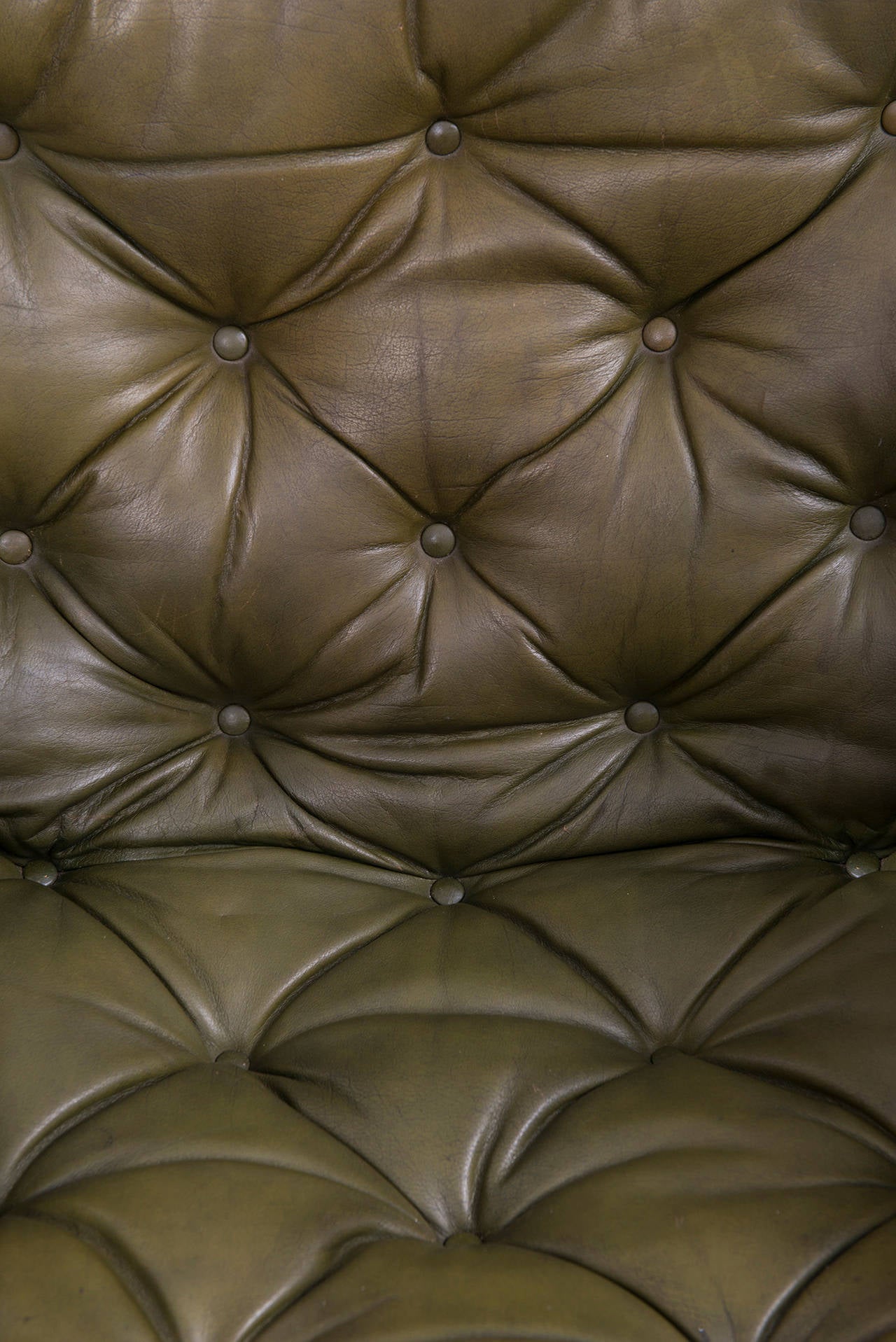 A pair of easy chairs in dark stained beech and tufted green leather designed by Arne Norell. Produced by Norell AB in Aneby, Sweden.