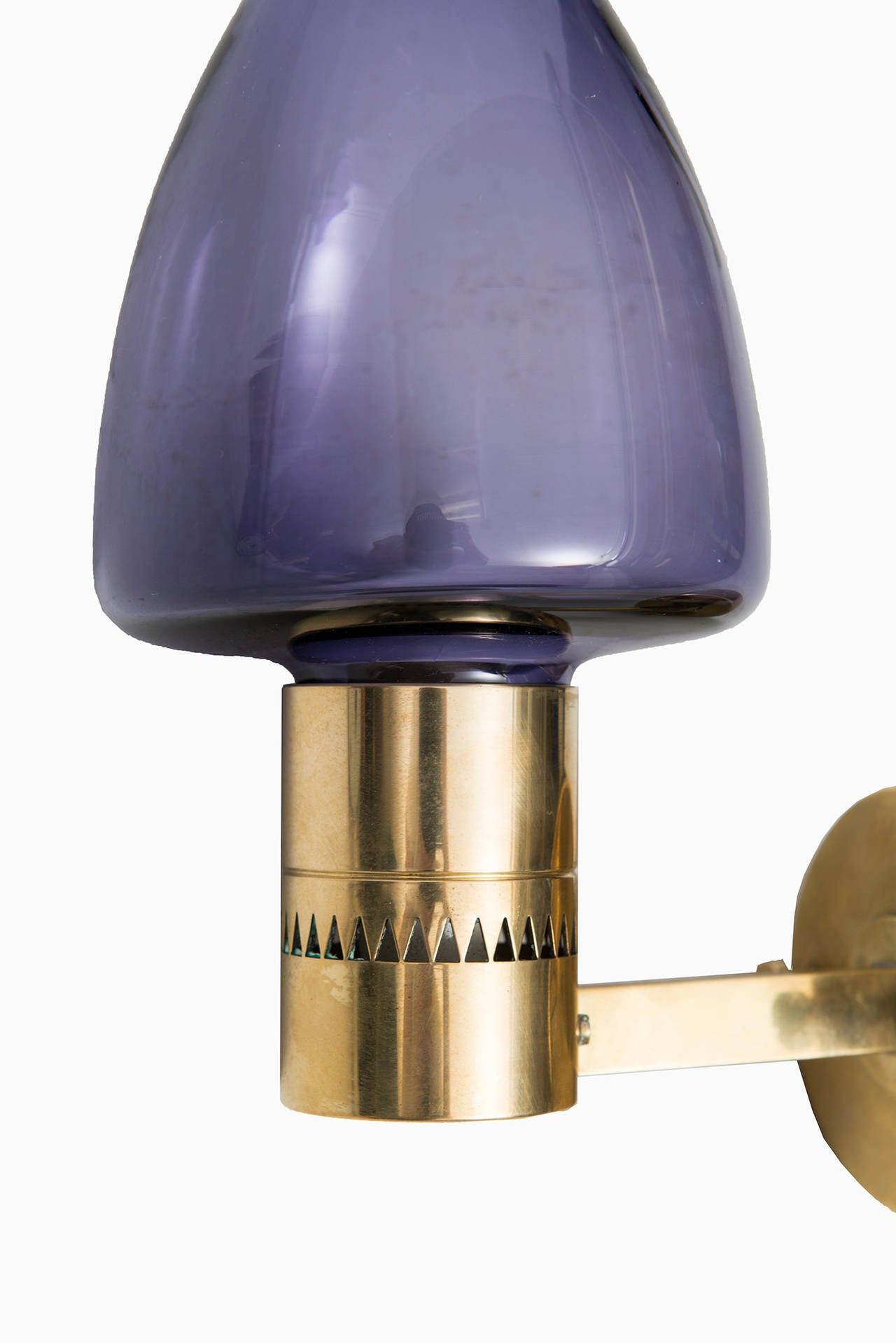 A pair of wall lamps in brass and purple glass designed by Hans-Agne Jakobsson. Produced by Hans-Agne Jakobsson in Markaryd, Sweden.