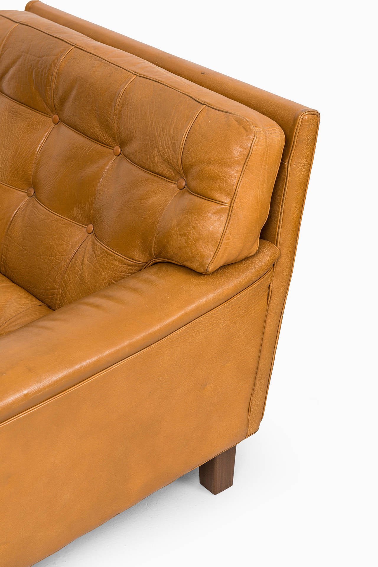 A pair of easy chairs model Merkur in cognac brown leather designed by Arne Norell. Produced by Norell AB in Sweden.