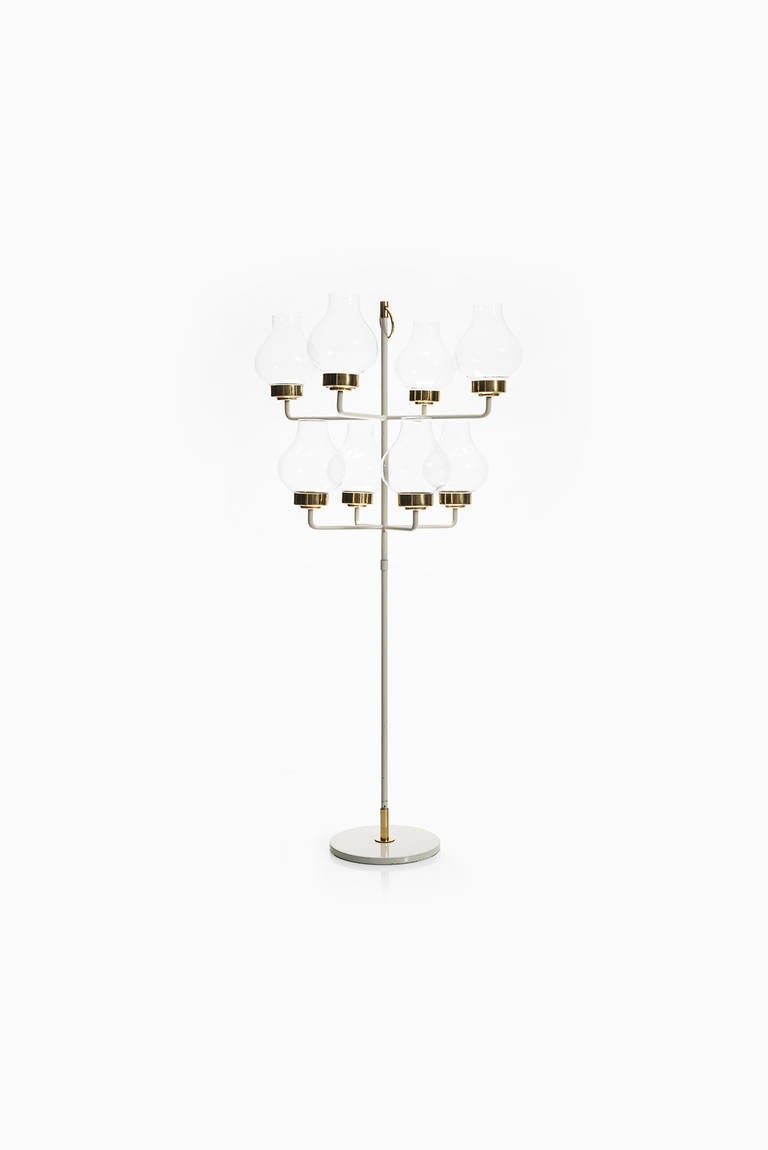 Rare Hans Bergström candlestick in brass, glass and white lacquered metal. Produced by Ateljé Lyktan in Åhus, Sweden.