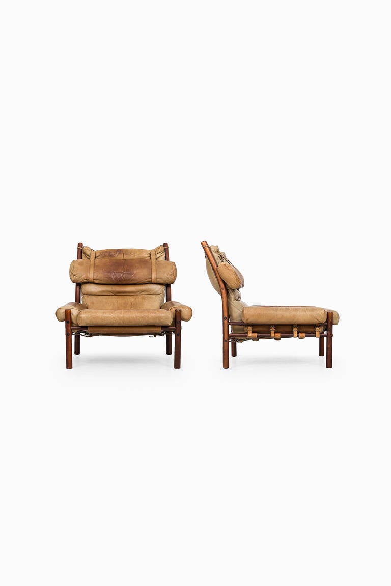 A pair of Inca easy chairs designed by Arne Norell. Produced by Arne Norell AB in Aneby, Sweden. Dark stained beech and original cognac brown leather with nice patina.