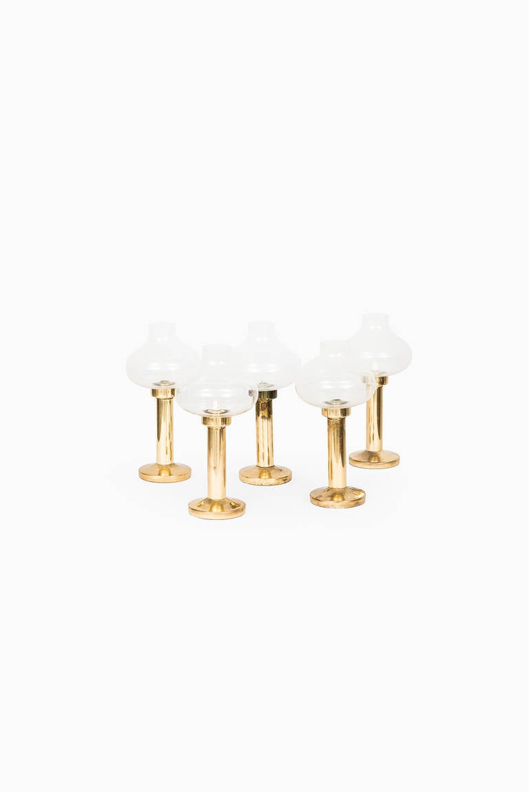 A set of 5 rare Anders Pehrson candlesticks in brass and clear glass. Produced by Ateljé Lyktan in Åhus, Sweden.