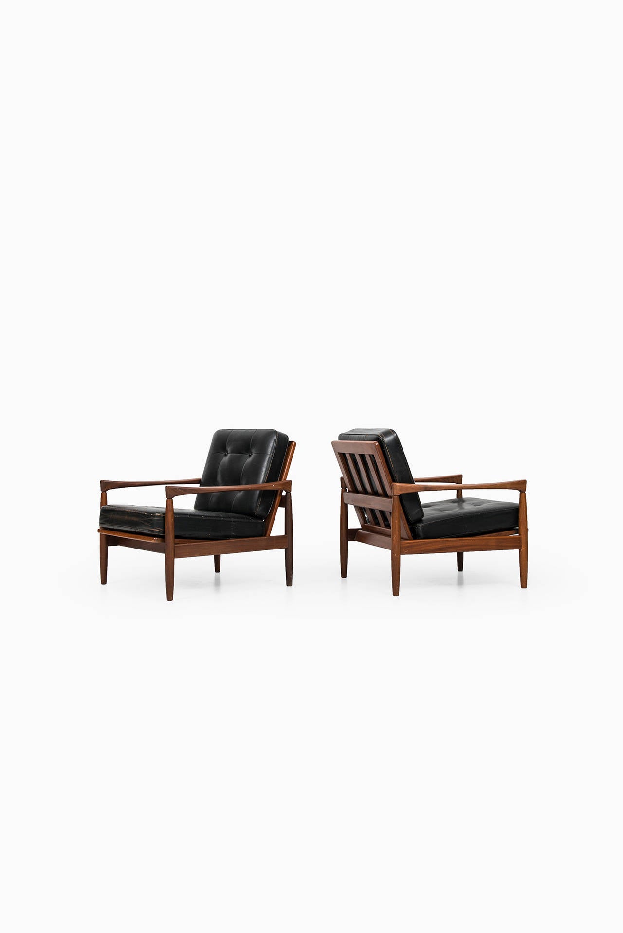 A pair of easy chairs model Kolding in teak and black leather designed by Erik Wørts. Produced by Bröderna Andersson in Sweden.