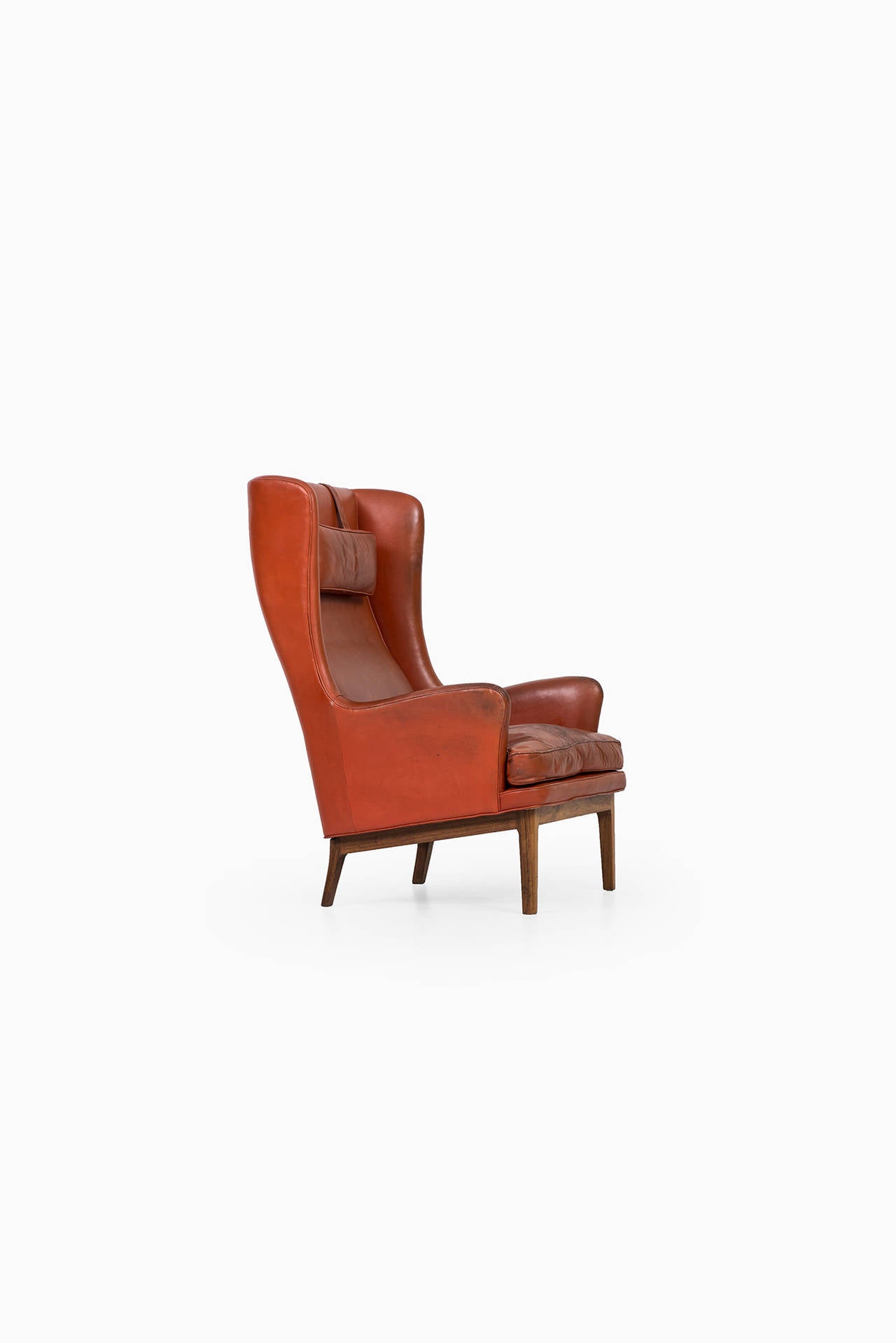 Rare wingback easy chair in rosewood and red leather designed by Arne Norell. Produced by Arne Norell AB in Aneby, Sweden.