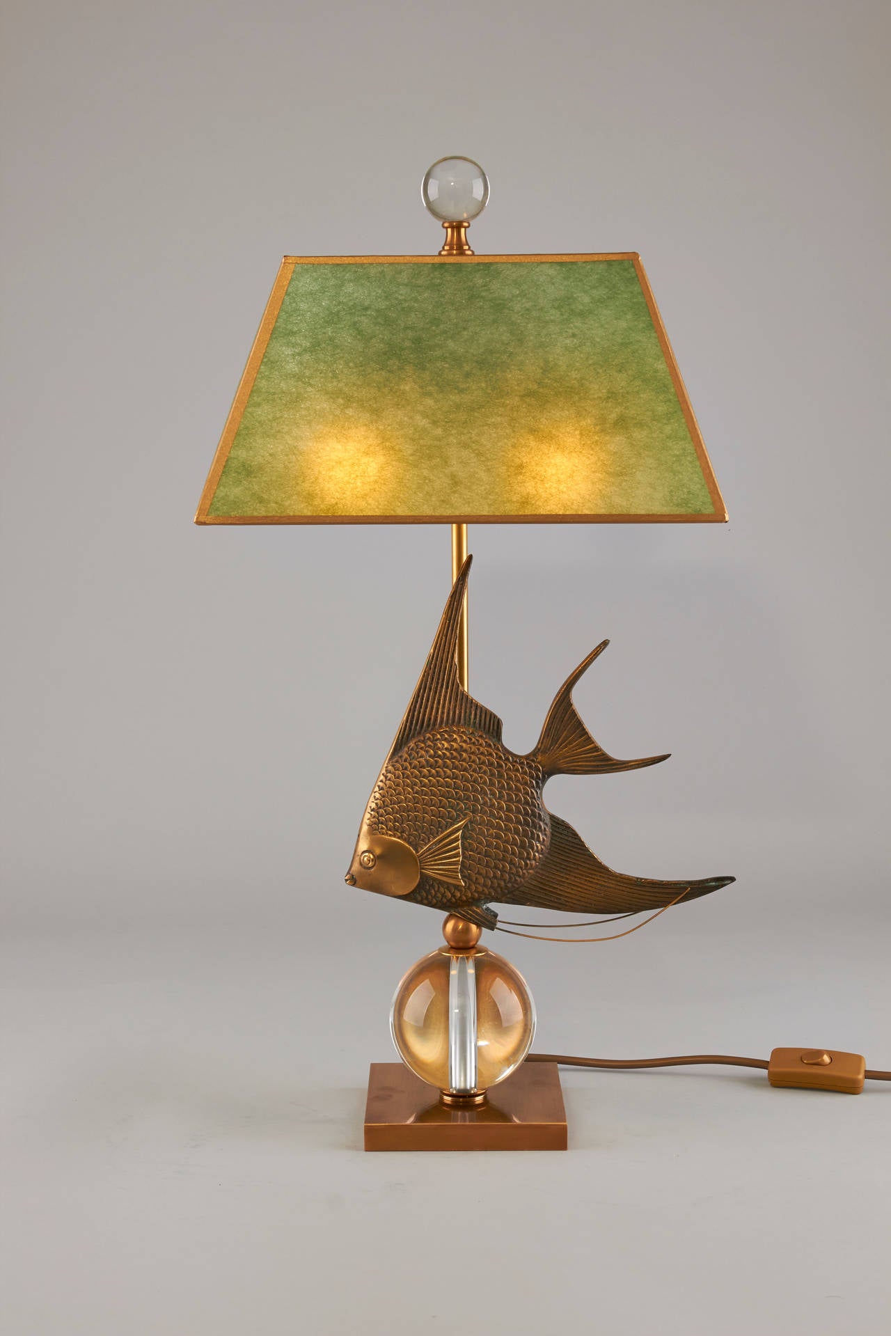 Unusual pair of table lamps. Mid-Century brass angel fish on a crystal ball.
One of a kind. Shade marbled paper.