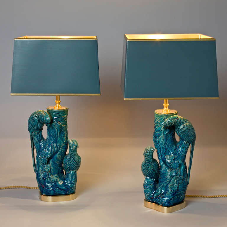 colorful birds on a tree trunk  Majolica, circa 1950 <br />
Pair of birds mounted as lamps<br />
Shades hand-painted gold inside<br />
Total Height 48 cm Individual item