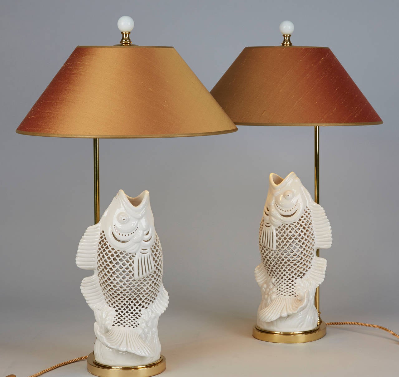 Pair of Table lamps  carved Porcelain Carp.
New mounted on brass base golden Silk shades.
Measurement including shade