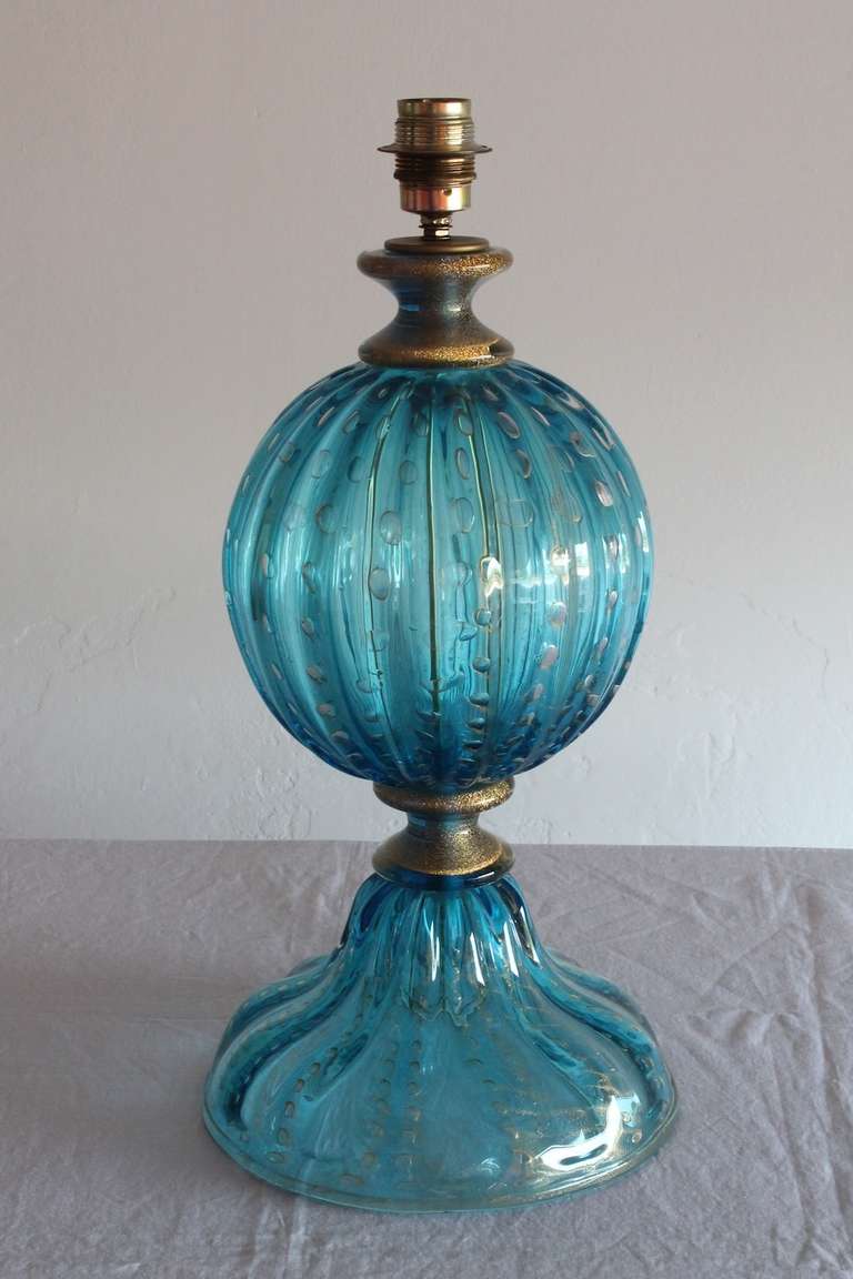 Spectacular ,Italian Table Lamp in Blown Murano Glass, Attributed to Seguso, 1960s in a sophisticated turquoise color with elegant gold rifiniture. Measure: The table lamp is 22.05 inches high, by 10.63 inches diameter.
The table lamp, is in perfect