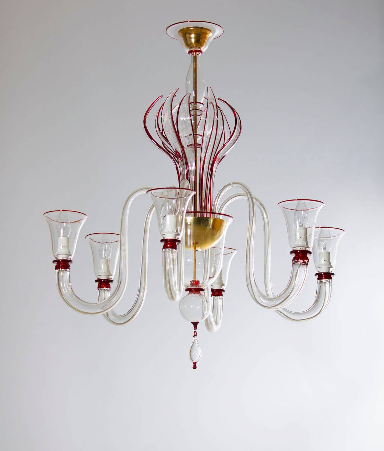 Particular Italian Murano chandelier, in amazing transparent color with red
refinishing, in excellent original condition from circa 1990s, composed by six arms, and with in the center a fantastic group of curved swords around of the sphere of the