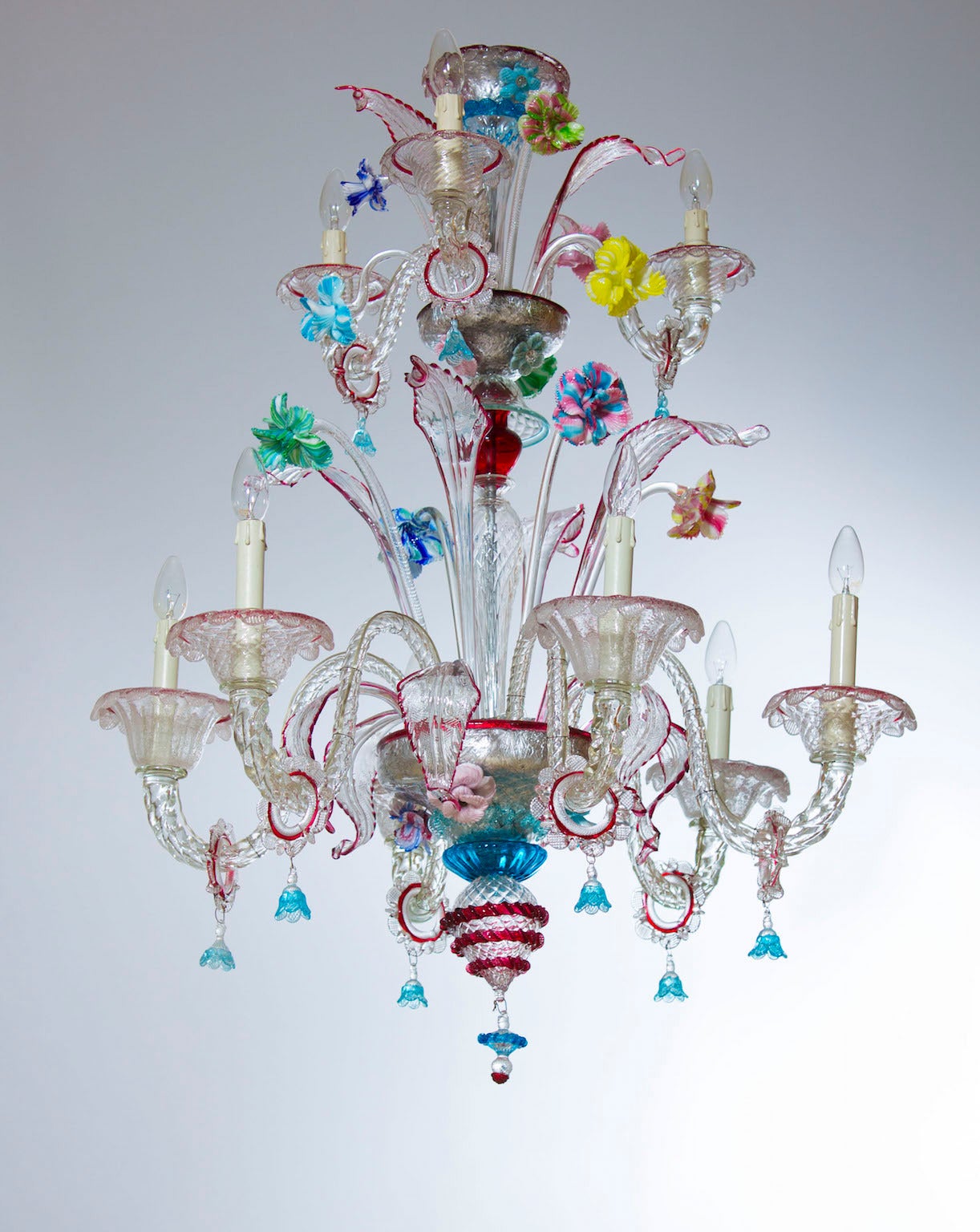 Elegant Italian Murano chandelier in beautiful transparent color with finishes in multicolored, in excellent original condition, circa 1950s, composed in the lower garden from six arms and six low leafs and from four high flowers and from four high