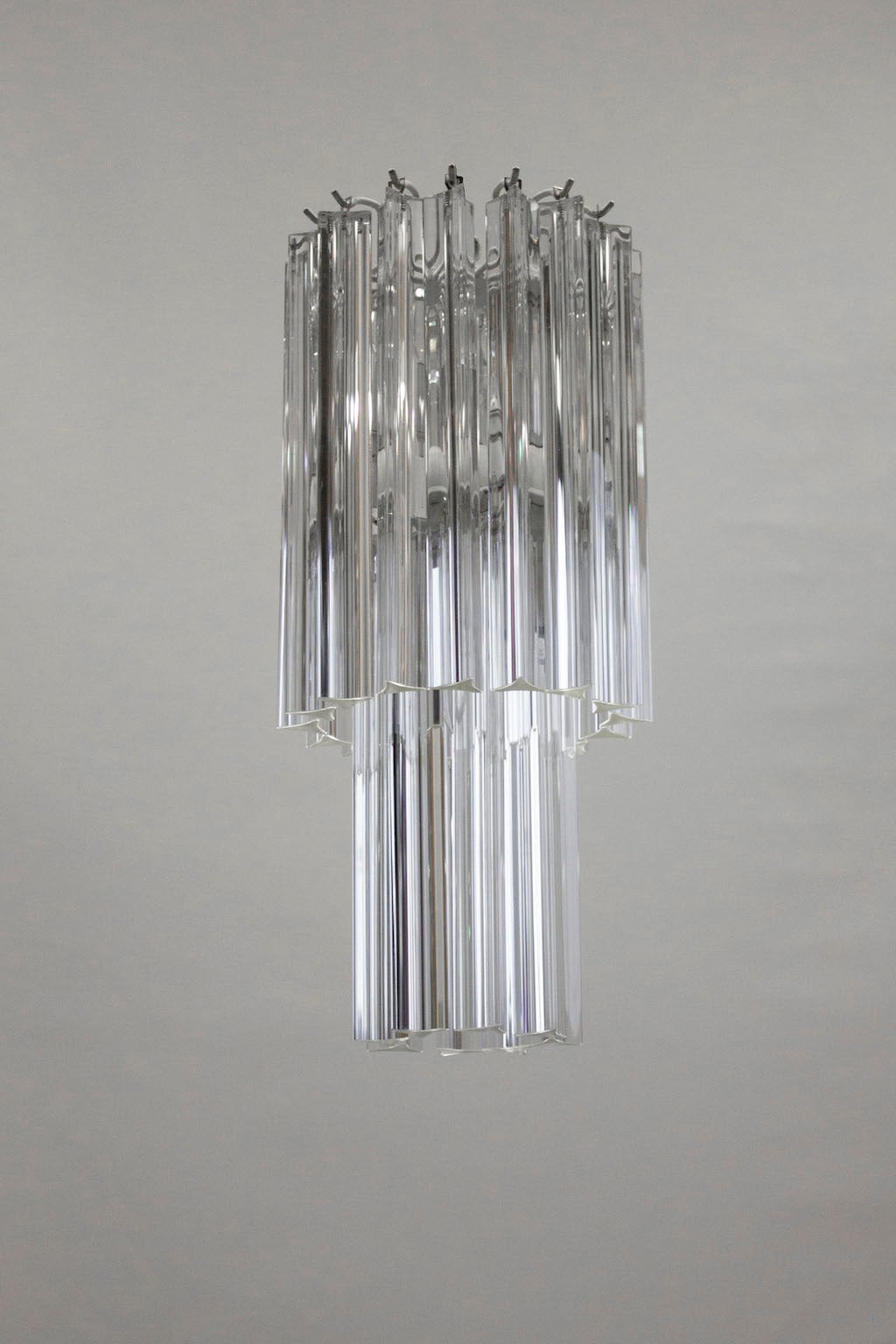 Amazing pair of Murano chandeliers in excellent original condition, attributed to Camer Glass, circa 1960, composed of elegant transparent triedro elements, with a white color frame. The chandelier is 15 inches high, by 8 inches diameter and having