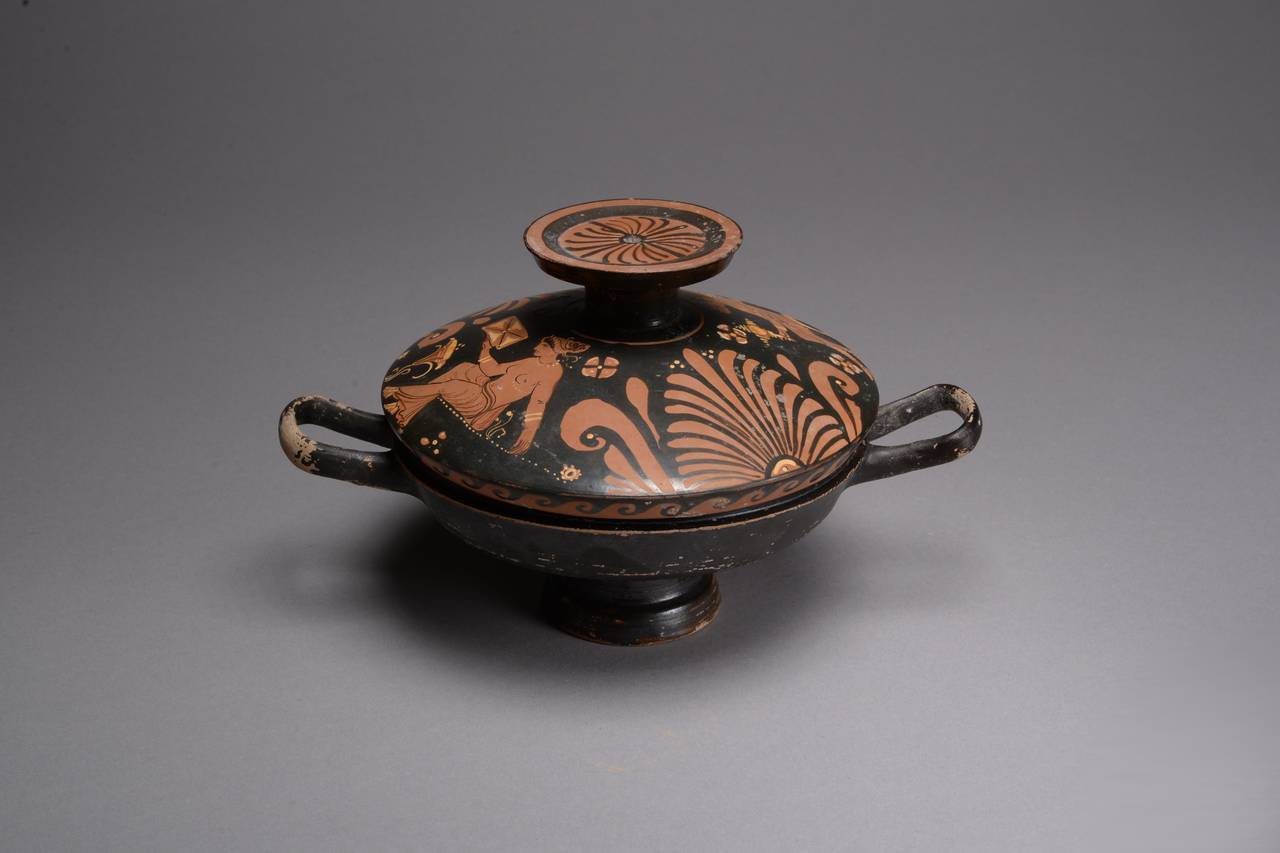 A beautiful ancient Greek Apulian red-figure lekanis, dating to 350–300 BC. 

The lekanis of typically elegant form, the shallow bowl painted in black, standing on a stemmed foot and with two wide ribbon-like handles set on the sides, the lid with