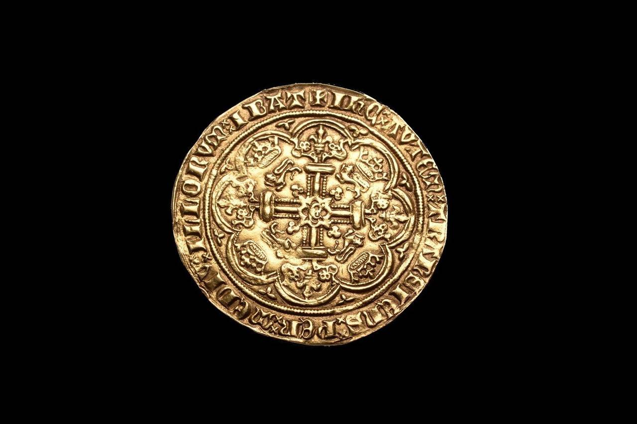 A medieval gold noble, minted under King Edward III of England, circa 1369 - 1377 at the London mint.

The obverse with Edward standing on the deck of a ship, facing the viewer and brandishing sword and shield, decorated with coat of arms of