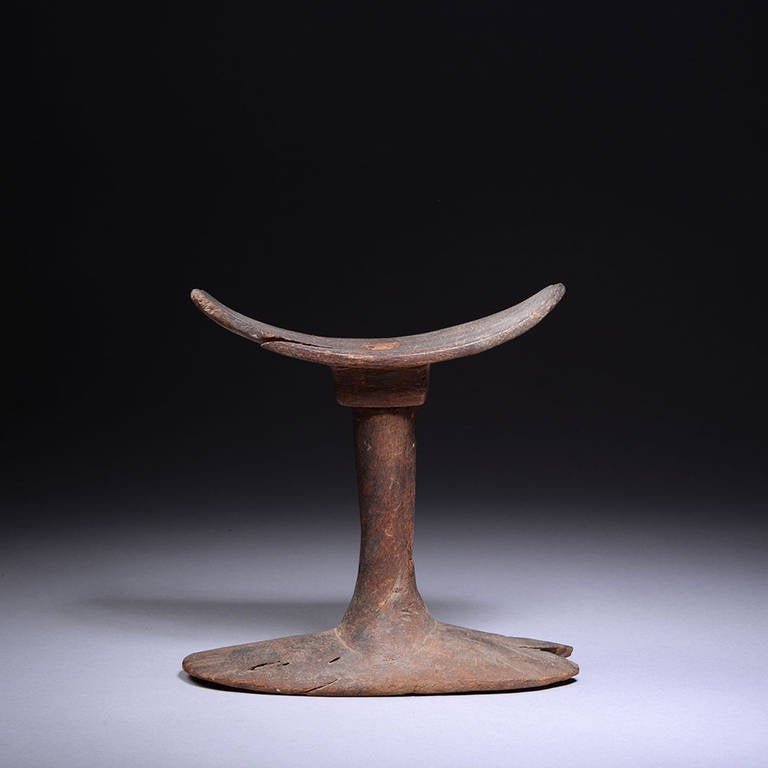 A well preserved ancient Egyptian wooden headrest, dating to the Old Kingdom, 2686 - 2181 BC.

The form of the headrest is one of simple elegance; the wide, sloping base with a flat foot, the cylindrical neck subtly tapering with a rectangular