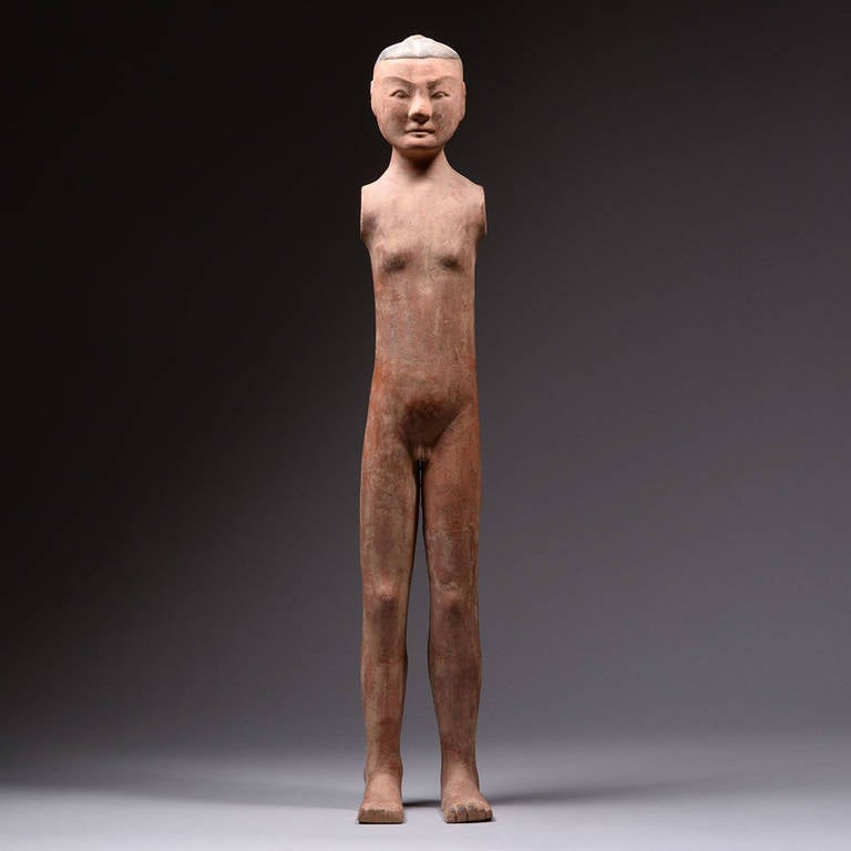 A striking, vibrant and decorative ancient Chinese Han Dynasty Yangling figure, dating to approximately 206 BC - 220 AD.

With a linear, slender form, this figure of a man is shown nude. His finely carved and painted facial features lend a sense